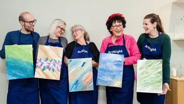 Fünf Personen halten Gemälde im Kunstkurs.