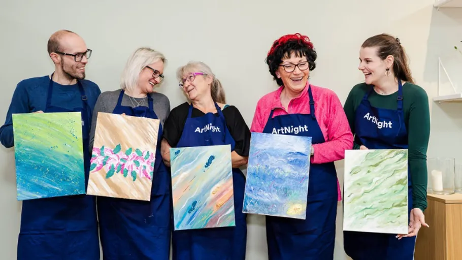 Five people holding paintings at art class.