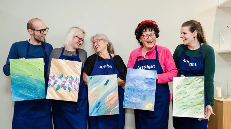Five people holding paintings at an art class.