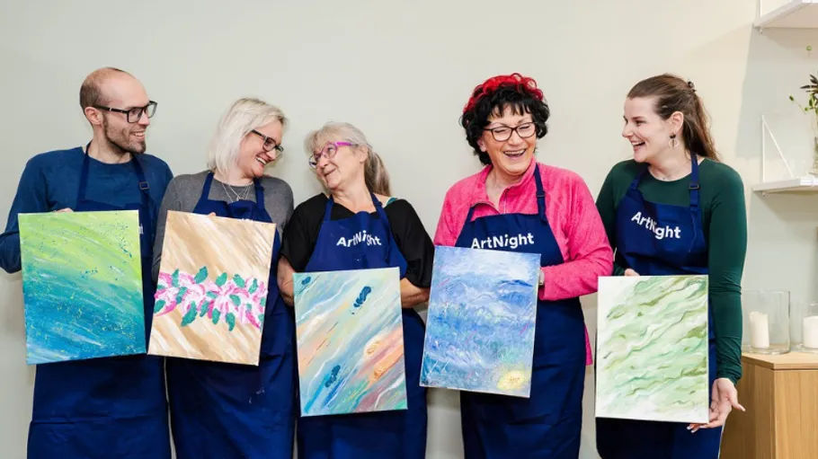 Group of people displaying their paintings.