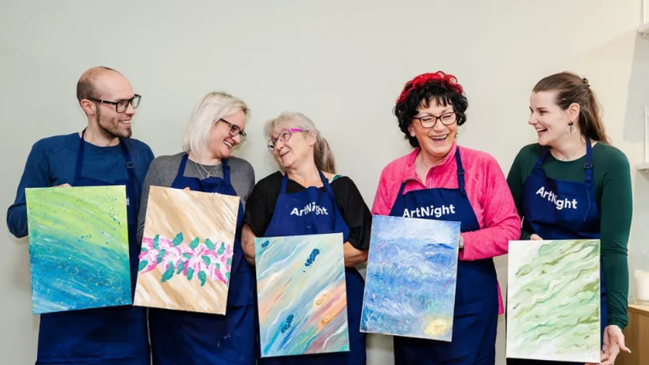 Five people smiling while holding paintings.