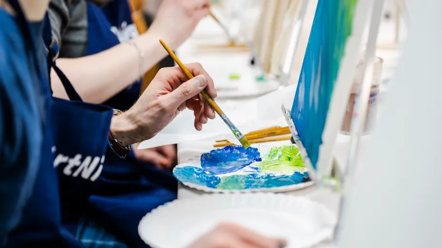 Person painting at group art class.