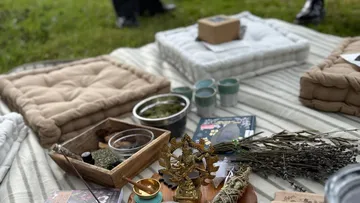 Kissen auf Rasen mit Dekoartikeln und Kräutern.
