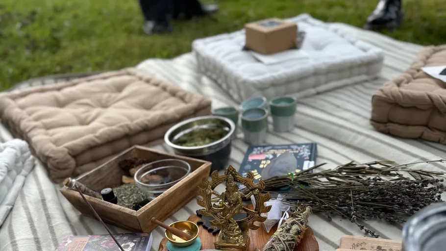 Cushions on grass with decorative items and herbs.