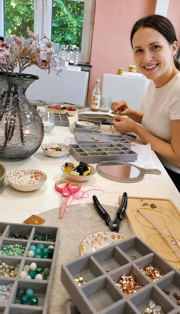 Woman making jewelry at a crafting table.