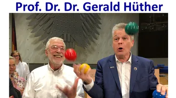 Zwei Männer jonglieren bunte Bälle drinnen.