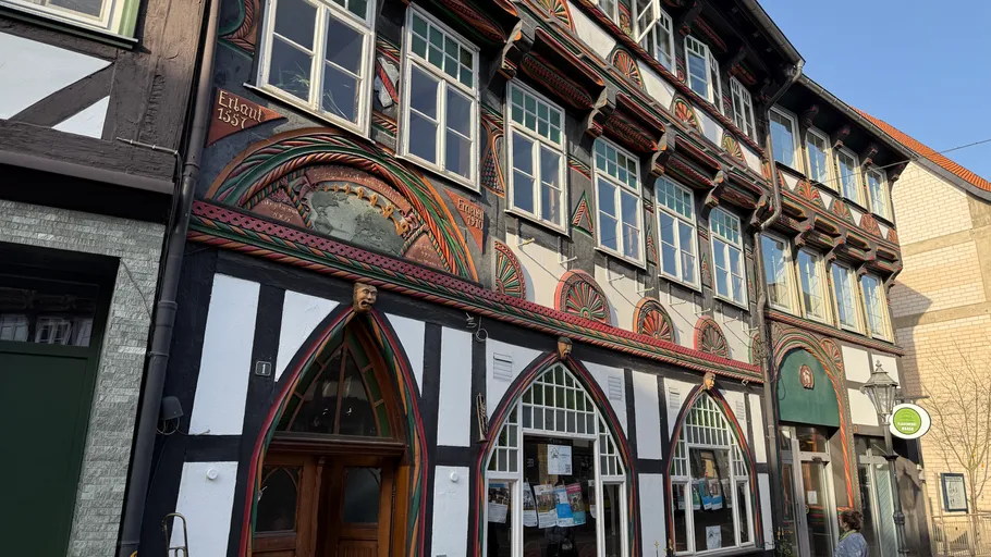Ornate timber-framed building on sunny street.