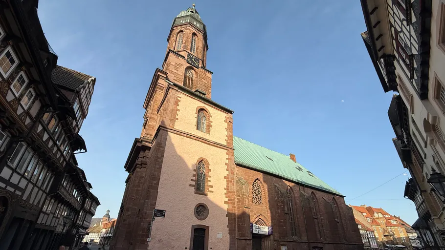 Historic church tower with surrounding buildings.