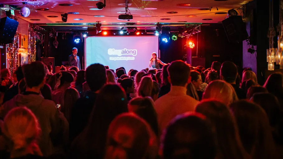 Crowd watching a singer on stage in a club.