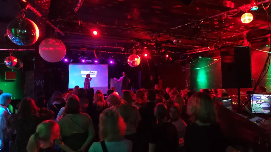 Crowd watching performers on a dimly lit stage.