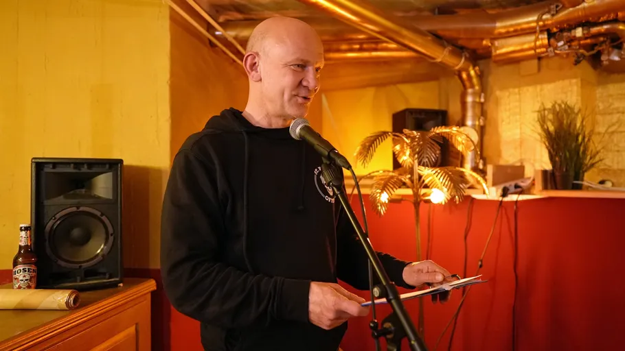 Man speaking into microphone in cozy room.