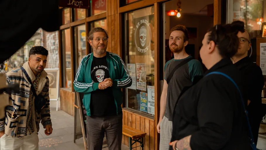 Five people talking outside a shop.
