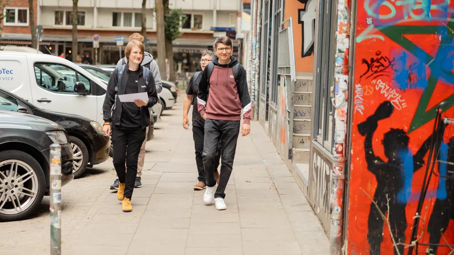 People walking on graffiti-covered street.