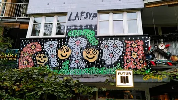 Graffiti with faces on building wall.