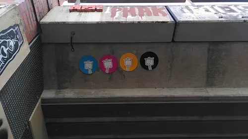 Colorful robot designs on urban concrete wall.