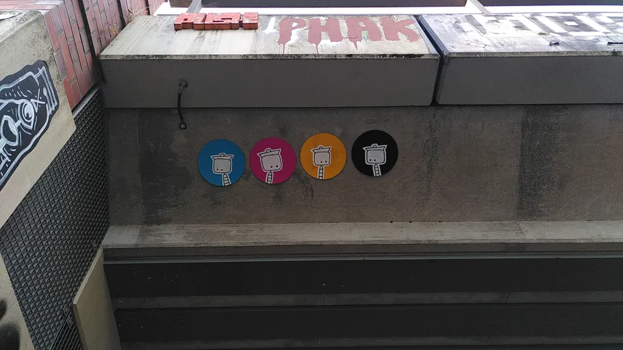 Colorful robot designs on urban concrete wall.