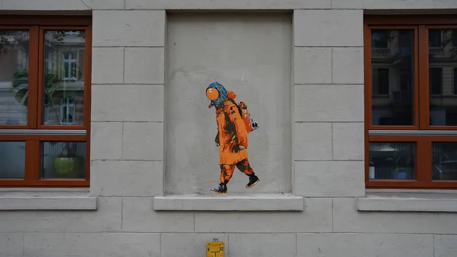 Astronaut graffiti on urban building wall.