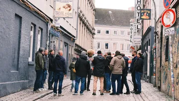 Gruppe von Menschen versammelt in enger Straße.