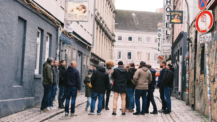 Group of people gathering in narrow street.