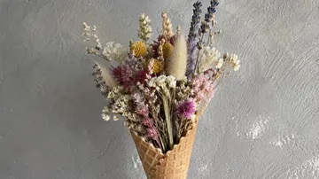 Getrocknete Blumen in einer Eistüte arrangiert.