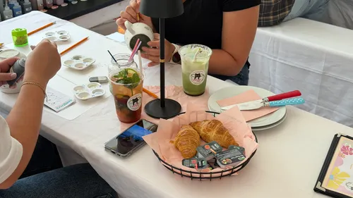 People painting cups at a table with drinks.
