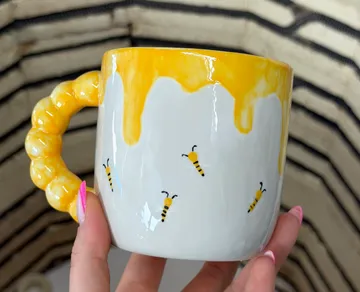 Bee-themed mug with honey handle design.
