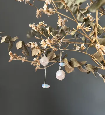 Dangling earrings on dried floral branches.