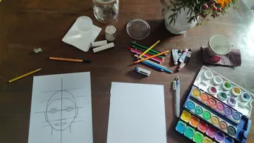 Drawing setup with art supplies on table.