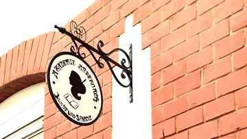 Sign with silhouette on brick wall.