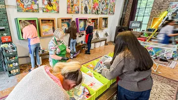People creating art in a colorful studio.
