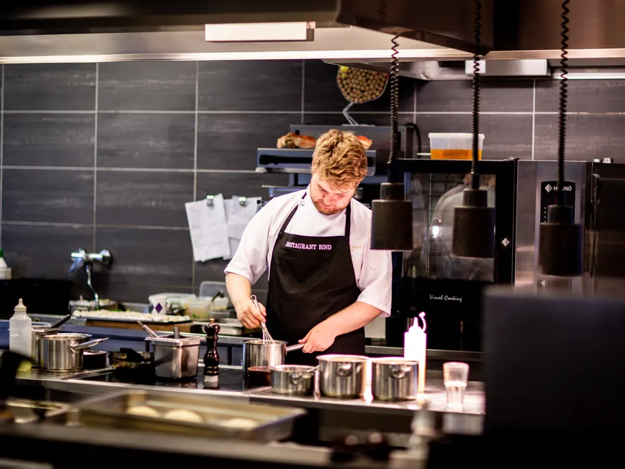 Koch rührt in Töpfen in einer modernen Restaurantküche.