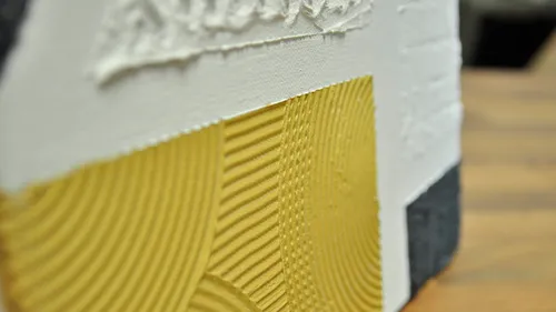 Textured wall sample with yellow pattern.