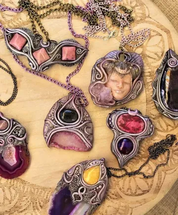 Colorful gemstone pendants on a wooden surface.