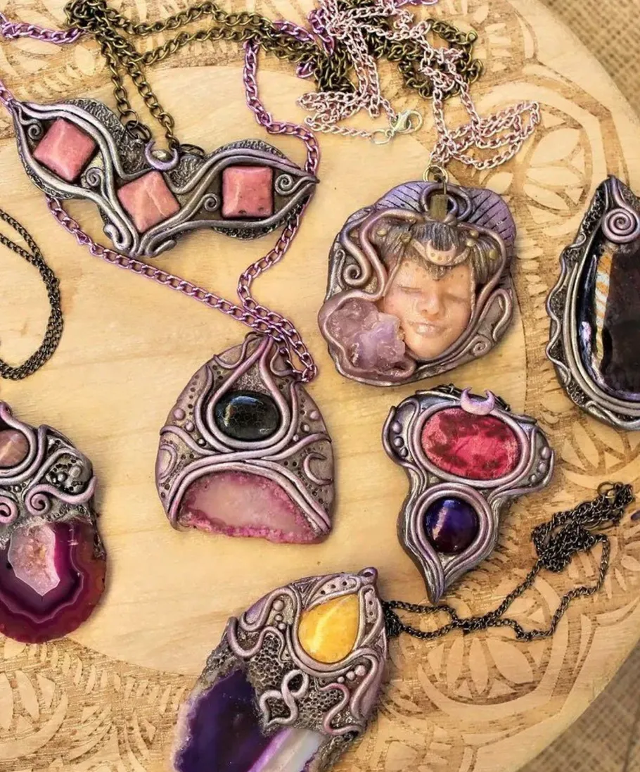 Colorful gemstone pendants on a wooden surface.