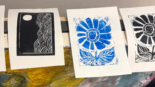 Printed artworks of moon and flowers on table.
