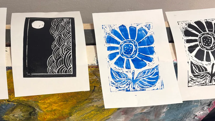 Printed artworks of moon and flowers on table.