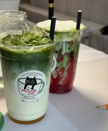 Zwei Eistee-Matcha-Getränke auf einem Tisch.