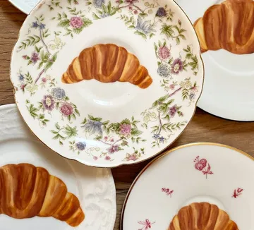 Teller mit Croissants und Blumenmustern.
