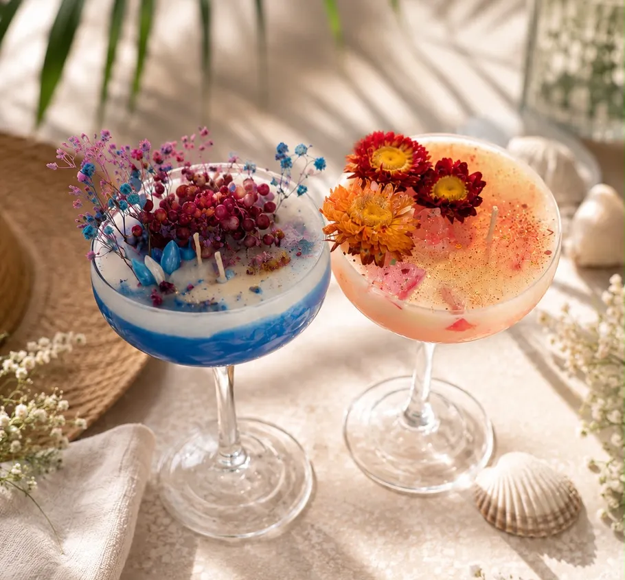 Decorative candles in glasses with flowers and berries.