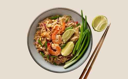 Shrimp pad Thai with lime and vegetables.