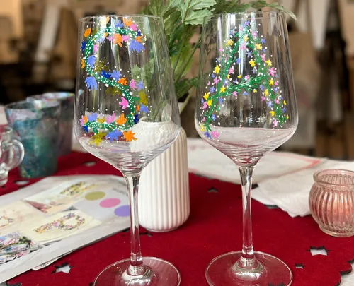 Two painted wine glasses on red tablecloth.