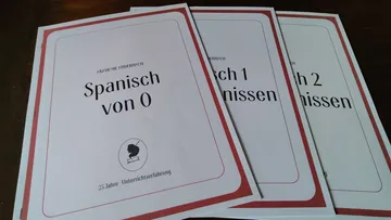 Three booklets on a wooden table.
