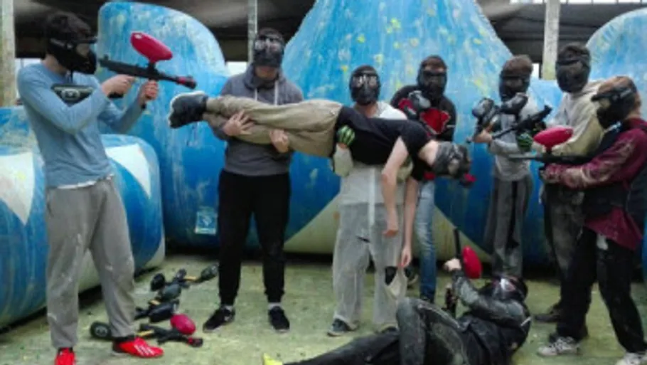 Gruppe hält Spieler in Paintball-Arena.