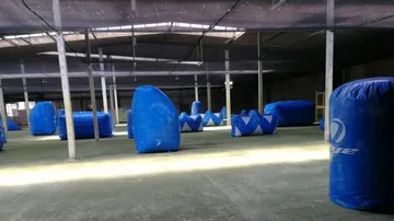 Indoor paintball arena with blue obstacles.