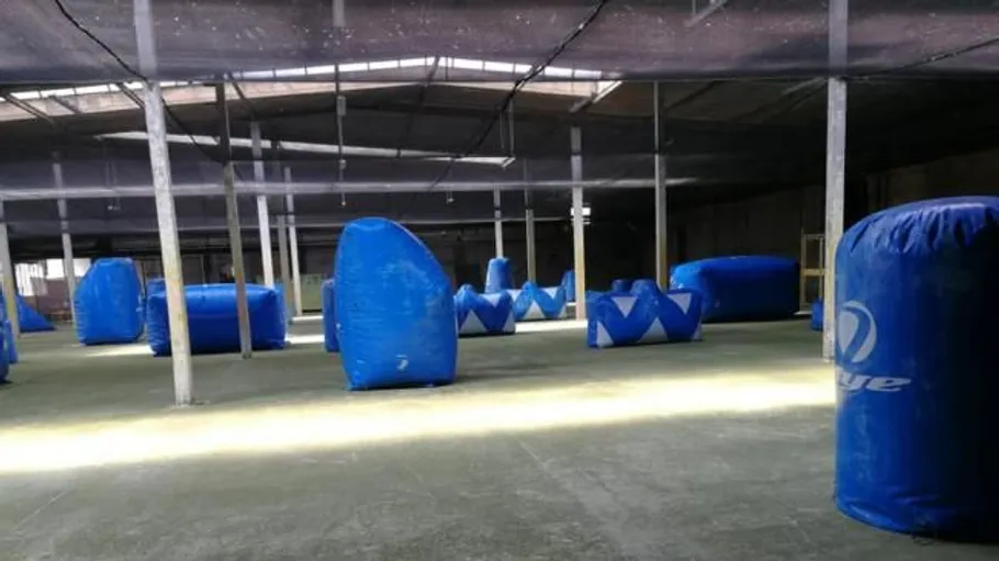 Indoor paintball arena with blue obstacles.