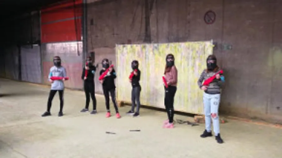 Personen halten Paintball-Waffen drinnen.