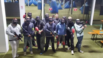 Gruppe mit Paintball-Gewehren drinnen.