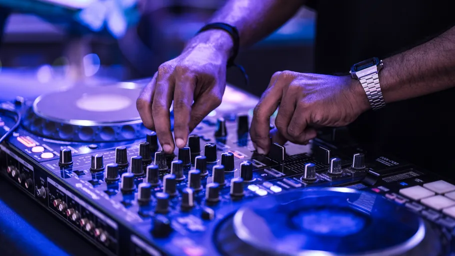 DJ justiert Mischpult bei einer Veranstaltung.