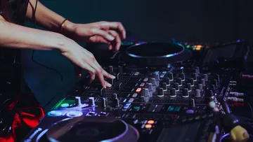 DJ passt Regler am Mischpult an.
