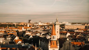 Cityscape with prominent clock tower at sunset.